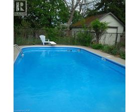 A blue swimming pool with a white chair by the side.
