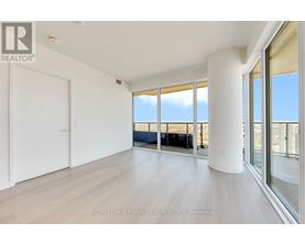 A spacious room with a view of the beach through large windows.