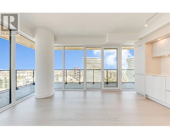 A spacious, well-lit room with large windows and a view of the cityscape.