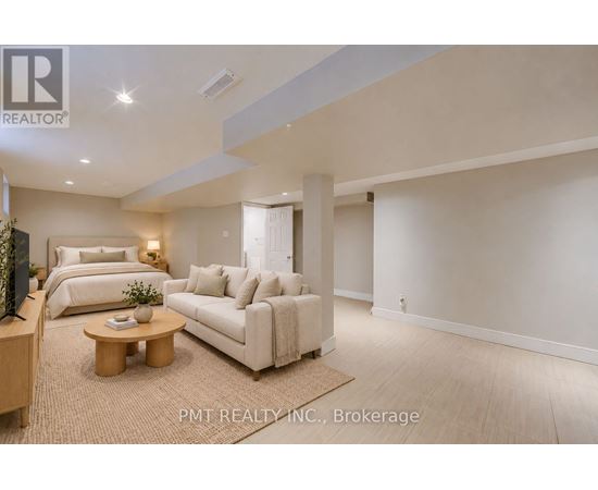 A well-lit, spacious living room with a sofa, bed, and television.
