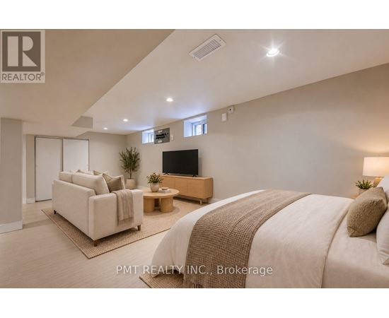 A well-lit bedroom with a large bed and a flat-screen TV.