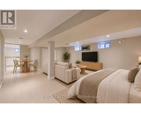 A well-lit, spacious bedroom with a large bed and a television.