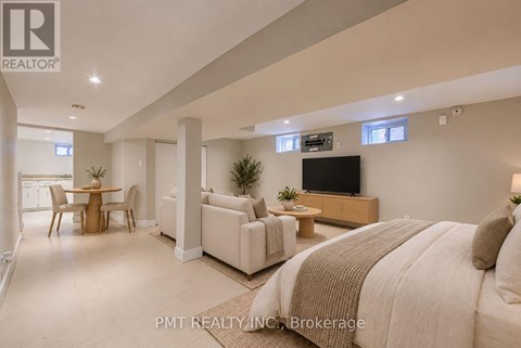 A well-lit, spacious bedroom with a large bed and a television.