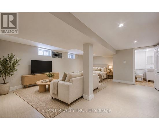 A living room with a flat screen TV and a large couch.