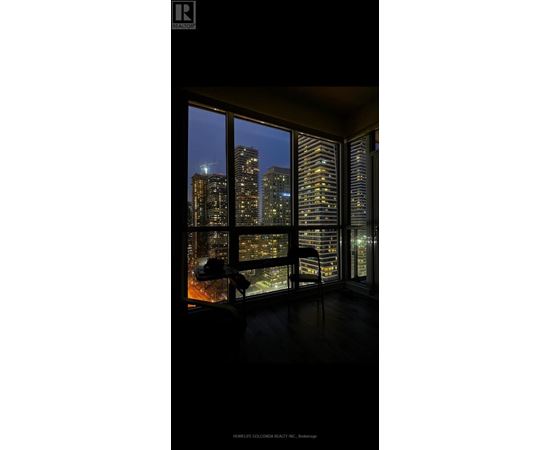 A room with a view of the city at night.