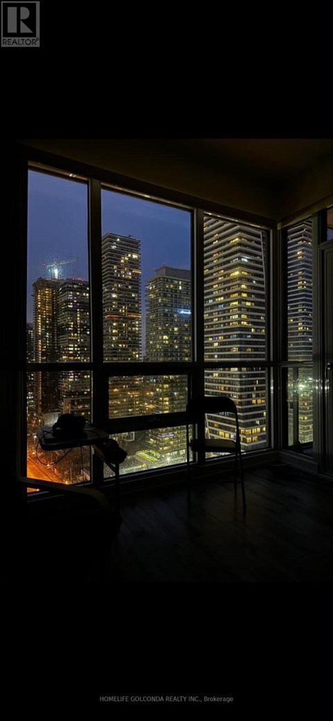 A room with a view of the city at night.
