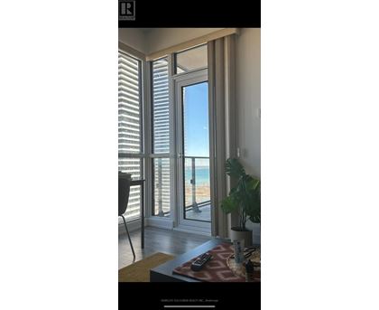 A room with a view of the beach through large windows.