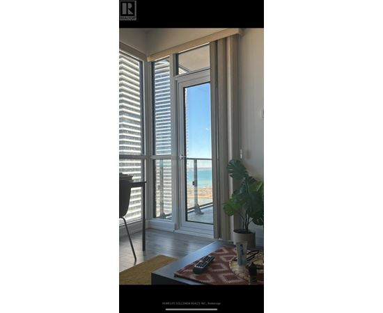 A room with a view of the beach through large windows.