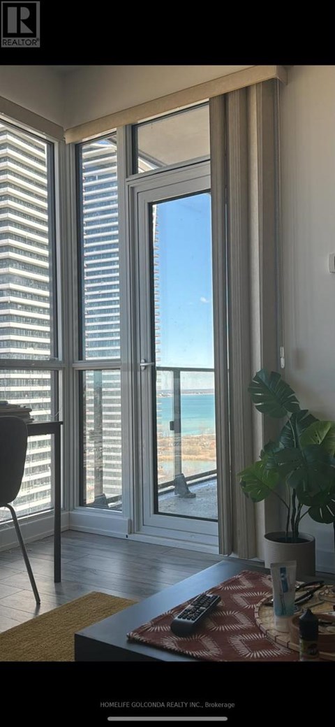 A room with a view of the beach through large windows.
