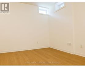 A room with wooden flooring and white walls.