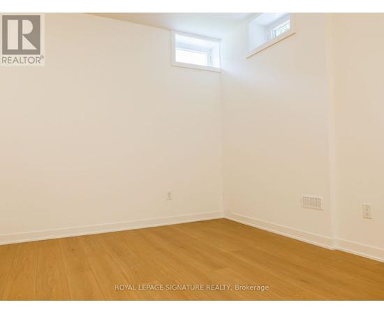 A room with wooden flooring and white walls.