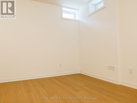A room with wooden flooring and white walls.