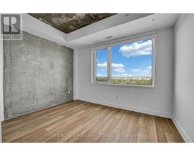A room with a large window showing a view of the sky and trees.