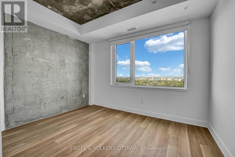 A room with a large window showing a view of the sky and trees.