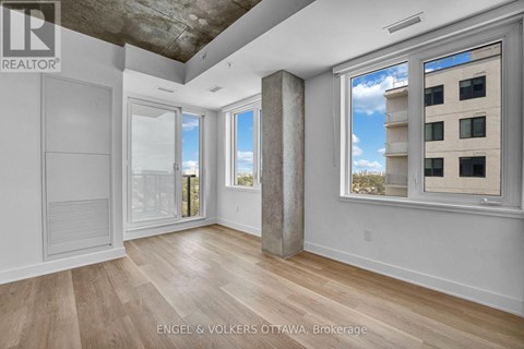 A room with a view of a building outside the window.