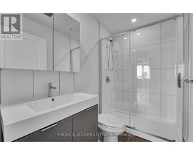A modern bathroom with a white sink and a walk-in shower.