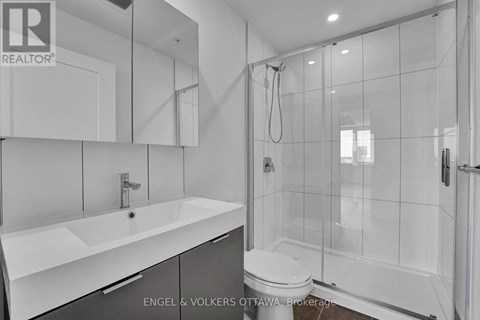 A modern bathroom with a white sink and a walk-in shower.