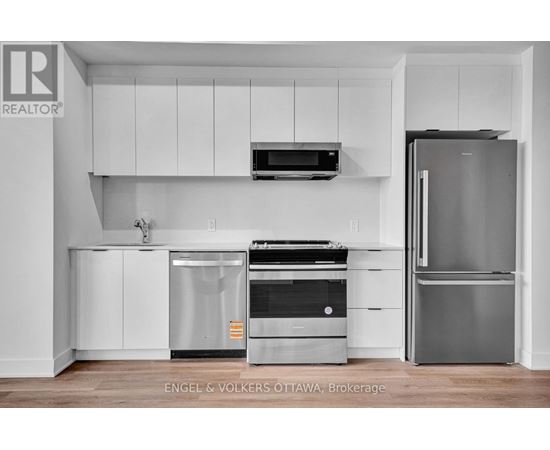 A modern kitchen with white cabinets and stainless steel appliances.