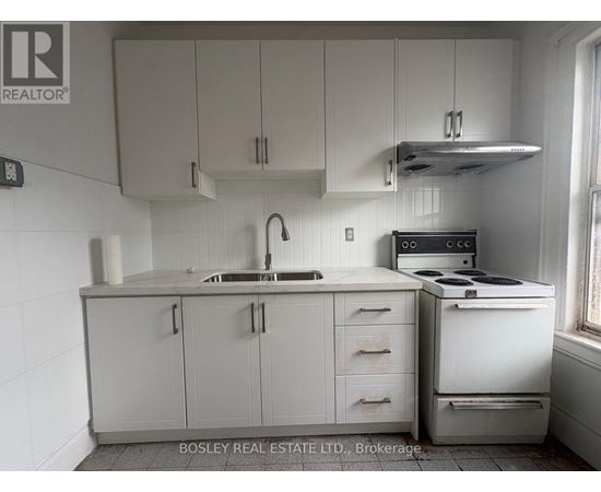 A kitchen with white cabinets and appliances.