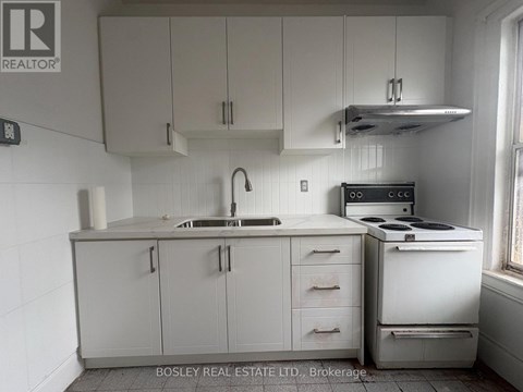 A kitchen with white cabinets and appliances.