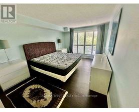 A bedroom with a large bed and a rug on the floor.