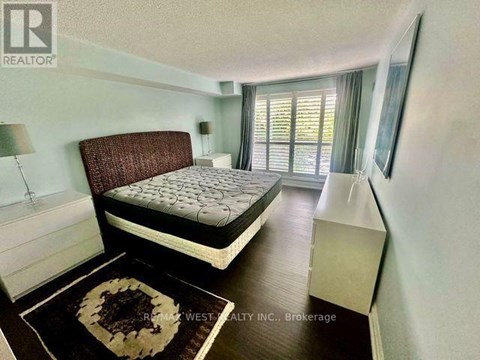 A bedroom with a large bed and a rug on the floor.