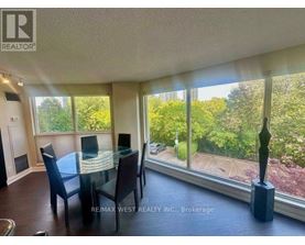 A dining room with a table and chairs and a view of the backyard.