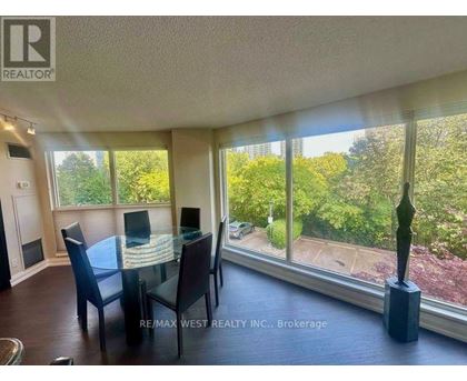 A dining room with a table and chairs and a view of the backyard.