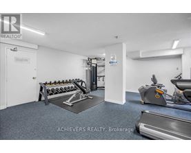 A gym room with a treadmill, exercise bike, and weights.