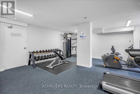 A gym room with a treadmill, exercise bike, and weights.