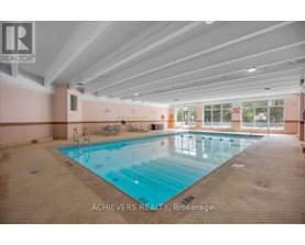 A large indoor swimming pool with lane markers and a diving board.