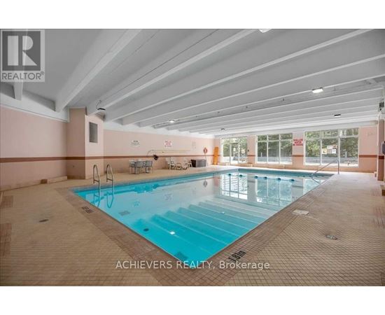 A large indoor swimming pool with lane markers and a diving board.