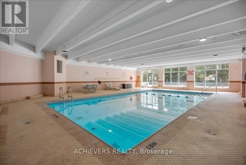 A large indoor swimming pool with lane markers and a diving board.