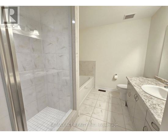 A white bathroom with a walk in shower and a toilet.