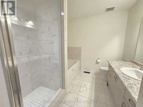 A white bathroom with a walk in shower and a toilet.