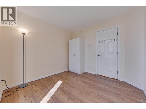 A room with a wooden floor and a white door.