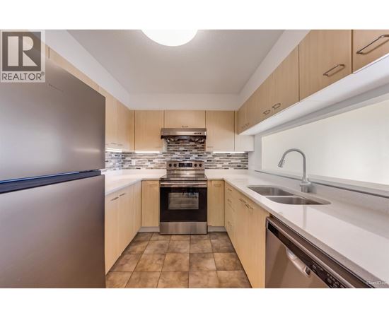 A modern kitchen with wooden cabinets and stainless steel appliances.