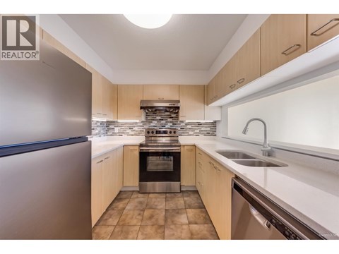 A modern kitchen with wooden cabinets and stainless steel appliances.