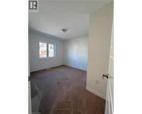 A room with a carpeted floor and a window.
