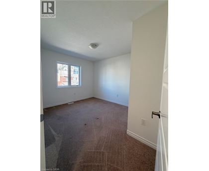 A room with a carpeted floor and a window.