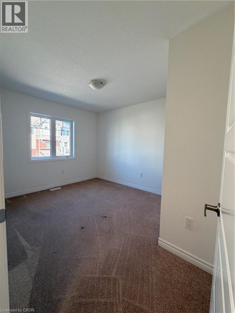 A room with a carpeted floor and a window.
