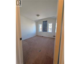 A room with a carpeted floor and a window with blinds.