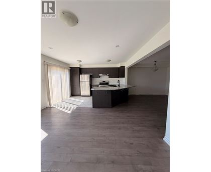 A spacious kitchen with dark wood floors and a large island.