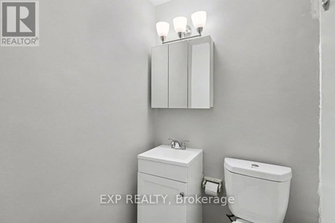 A white toilet and sink in a bathroom.