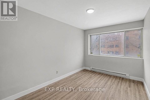 A room with a window showing a view of a building outside.