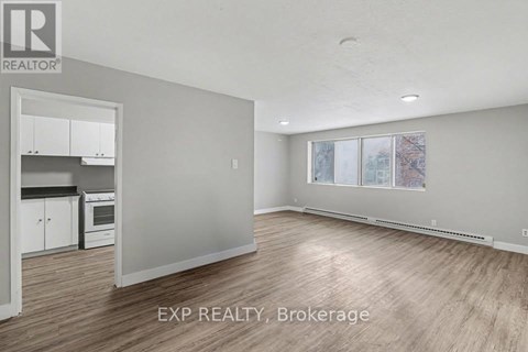 A room with a kitchen area and a dining table.