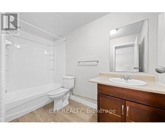 A white bathroom with a toilet, sink, and bathtub.
