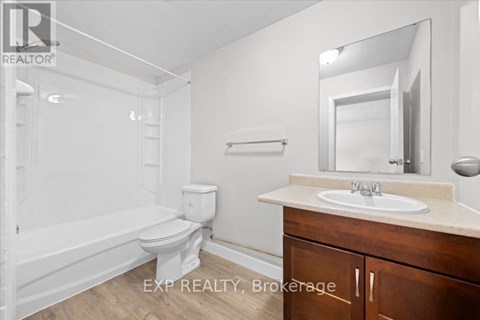 A white bathroom with a toilet, sink, and bathtub.