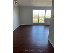 A room with wooden floors and a large window overlooking a balcony.