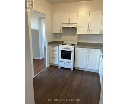 A kitchen with white cabinets and a stove top oven.